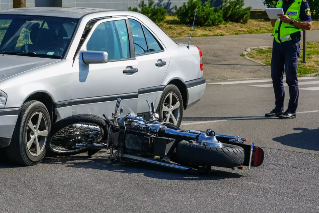 Motorcycle hit by a car in the street.