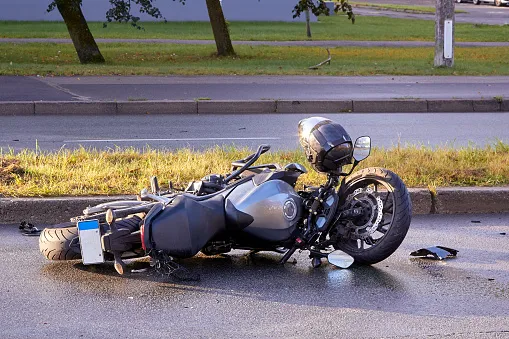 A broken motorcycle on the side of the road.