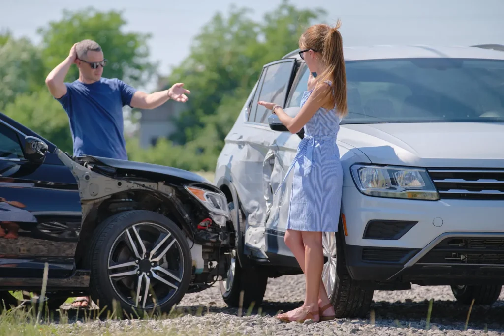 Two people talking after a car accident.