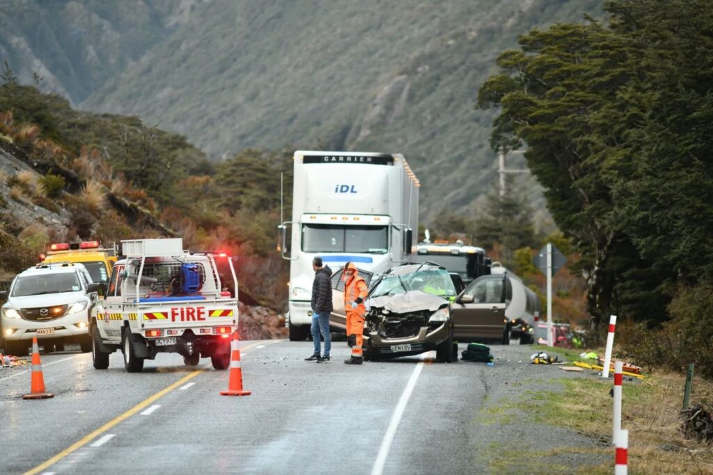 An accident scene with an 18-wheeler truck and another car.