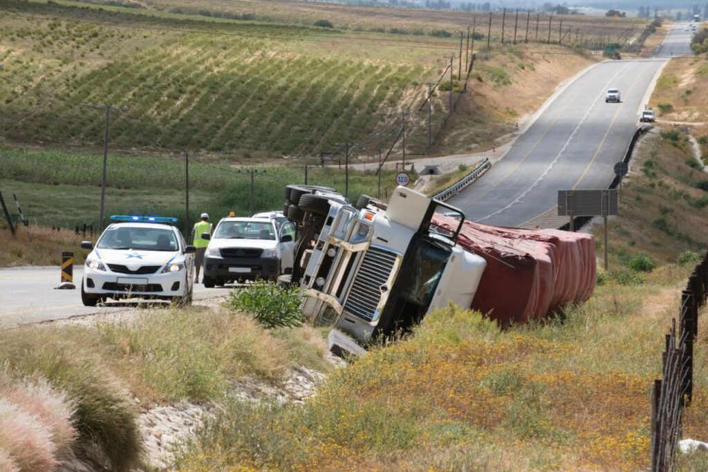 A truck crash on the side of the road.