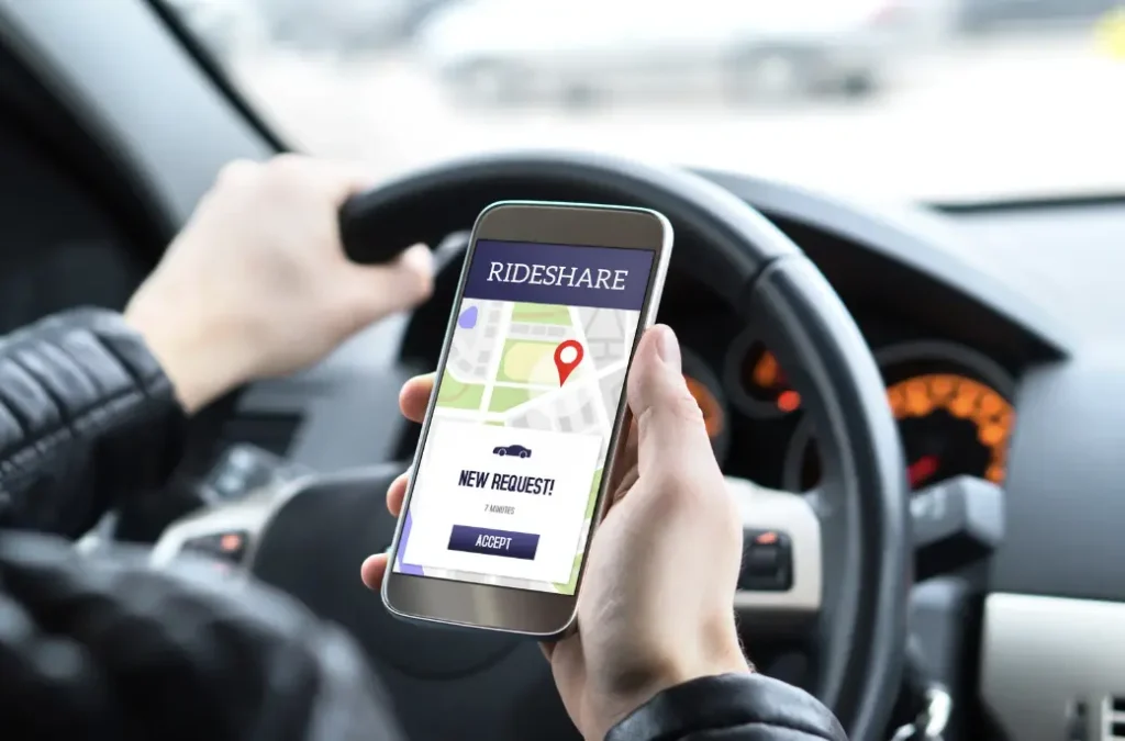 Person holding smartphone with rideshare app open.