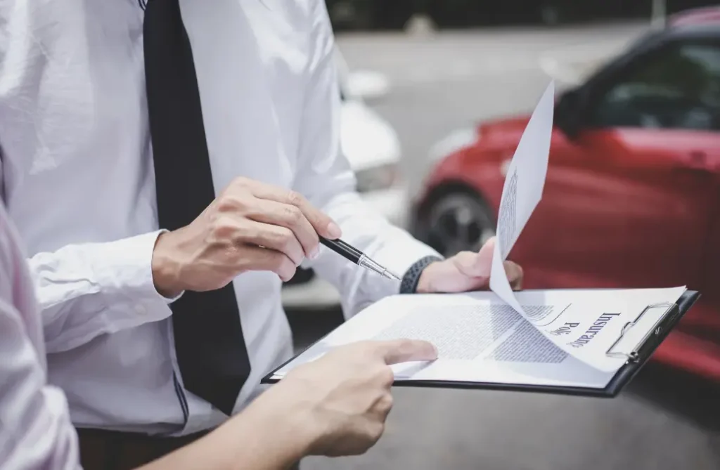 Two people filling an insurance form after a car accident.