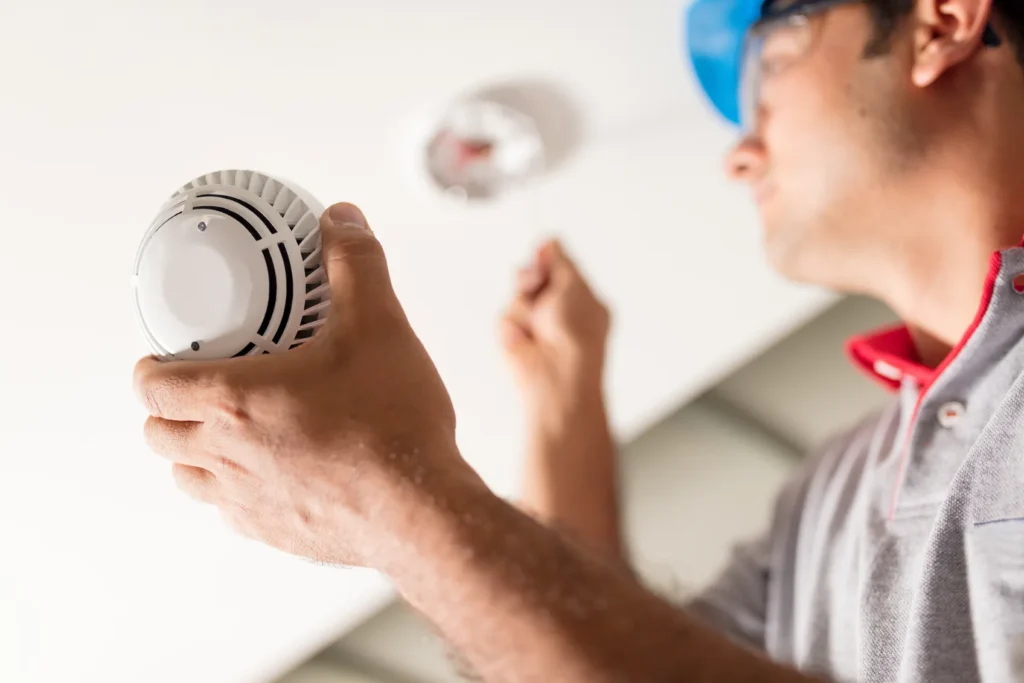 A man changing a carbon monoxide alarm.